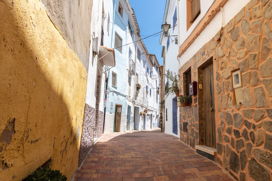 Fototapeta Narrow streets of Chelva, picturesque and brightly painted houses, on a sunny day.