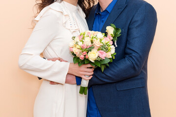 Bride and groom holding hands showing their rings, wedding couple holding bouquet