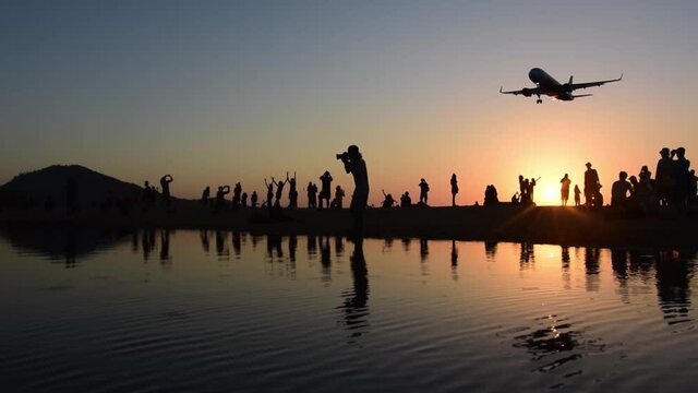 Airplanes landing, people below taking pictures of planes