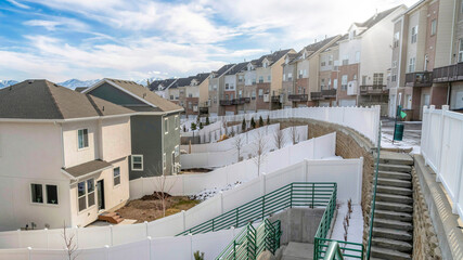 Pano Snowy neighborhood landscape with stairs and road amid homes and townhouses