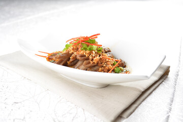 Braised duck tongue meat with spicy dark soy sauce platter set in white background appetiser halal menu