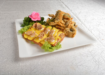 Deep fried egg skin crepe with mango fruit, walnut and salted egg yolk fish skin platter in white background appetiser halal menu