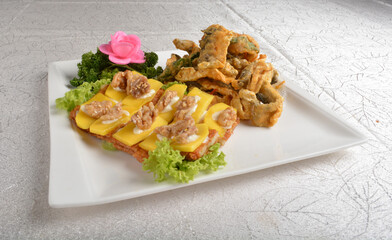Deep fried egg skin crepe with mango fruit, walnut and salted egg yolk fish skin platter in white background appetiser halal menu
