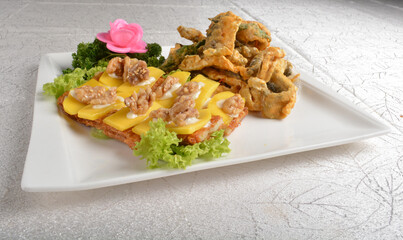 Deep fried egg skin crepe with mango fruit, walnut and salted egg yolk fish skin platter in white background appetiser halal menu