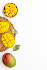 Mango fruits and mango cubes in bowl. Tropical breakfast. Overhead view