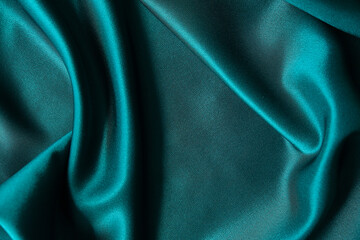 Blue silk drapery and upholstery fabric from the courtyard. Blue satin, silky fabric, wave, draperies. Beautiful textile backdrop. Close-up. Top view