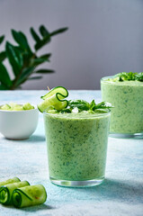 Cucumber Gazpacho - cold summer soup with basil in glasses on light background