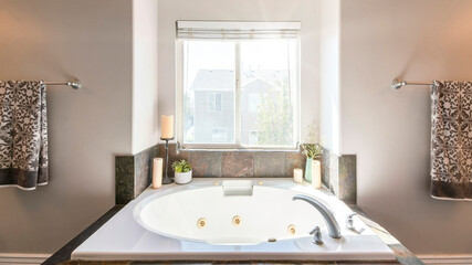 Pano Interior of a bathroom with drop in tub and brown rough tiles