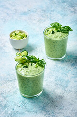 Cucumber Gazpacho - cold summer soup with basil in glasses on light background