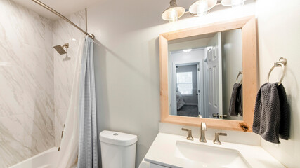 Pano Small bathroom interior with single vanity sink and shower tub with tile walls