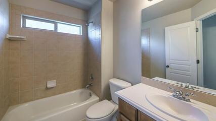 Pano Bathroom interior with single vanity sink and bathtub shower unit with ceramic tiles surround