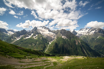 Obraz premium Mountain landscape on a sunny summer day. Blue sky with clouds. Dombay, Karachay-Cherkess region. A ski resort.