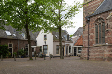 Small white house with bicycles near the church on the village square of Loenen aan de Vecht in the province of Utrecht.