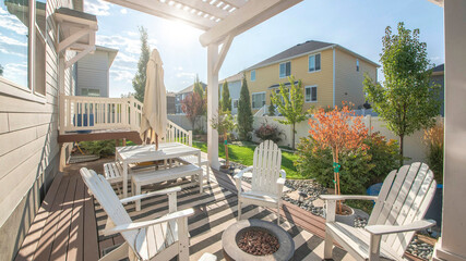 Pano Backyard of a house with a pergola covered patio beside the small door deck - obrazy, fototapety, plakaty