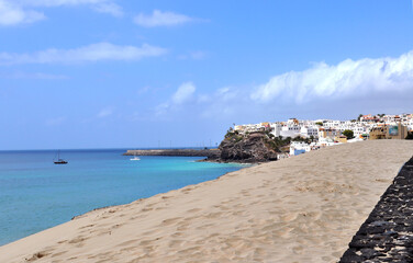 Ocean view, beach with a huge sand dune and part of the city of Morro Jable, Fuerteventura, Canary Islands, Spain.