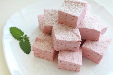 sweet confectionery - pastila (pink marshmallow) cubes on a white plate