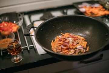 Frying pan with vegetables and meat close-up.