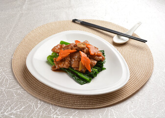 Stir fried vegetables with slices wagyu beef meat in dark soy sauce on white background Asia halal menu