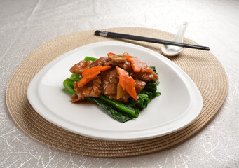 Stir fried vegetables with slices wagyu beef meat in dark soy sauce on white background Asia halal menu