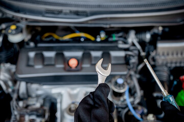Technician is using a wrench and screwdriver for repair car in car service and maintenance concept