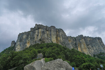 Fototapeta na wymiar View of the Pietra di Bismantova rock in Italy, Reggio Emilia from beneath across dramatic sky. Mountains landscape