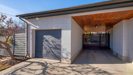 Pano Exterior of a garage with a wooden ceiling and the sun shines.