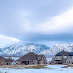 Fototapeta na wymiar Square Lake front homes on a snowy neighborhood setting with Wasatch Mountains view