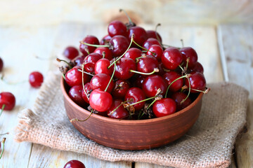Selective focus. Ripe juicy cherries in a bowl on a wooden surface. Organic cherry harvest.