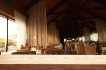 image of wooden table in front of abstract blurred background of lights of restaurant bar cafe