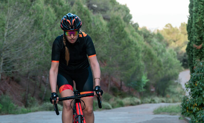 young caucasian cyclist riding a bike surrounded by trees