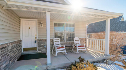 Pano Open porch of one storey house with white siding and stone bricks on wall