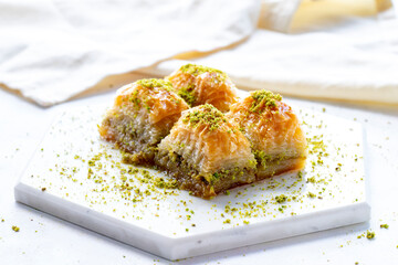 Baklava with pistachio on a white wooden background. Baklava on a marble floor