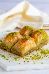 Baklava with pistachio on a white wooden background. Baklava on a marble floor. Close up