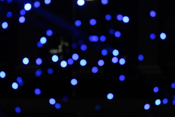 blue garlands on a dark black background. New Year's Eve christmas background. Festive lighting
