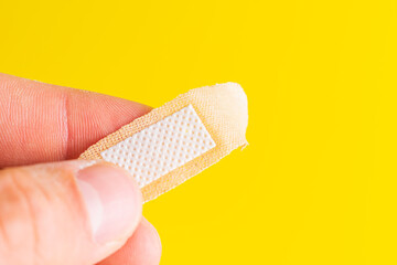 Medical adhesive plaster. Adhesive bandage plaster on yellow background