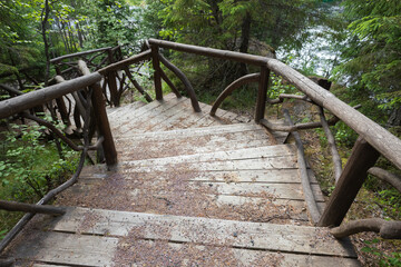 Wooden stairway goes down in the forest