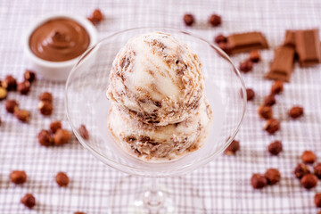 Chocolate ice cream in a glass with ingredients used to decorate the background