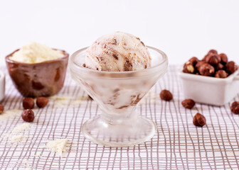 Powdered milk ice cream with chocolate in a glass with ingredients used to decorate the background