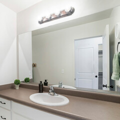 Square frame Interior of a bathroom with white marble top sink with white cabinet and mirror