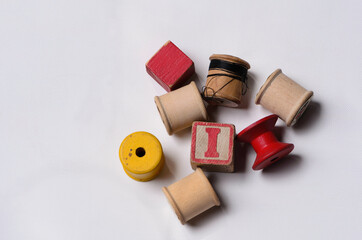 Vintage wooden spools and block on white background