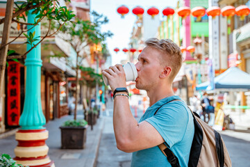 A young man walks around Chinatown and drinks coffee. San Francisco, USA - 18 Apr 2021