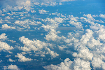 Clouds against blue sky view through an airplane window for a background.