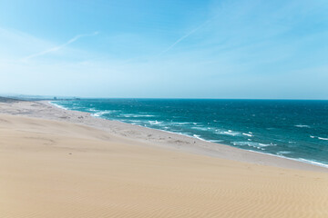 The high view of Japan Sea from the famous hill Umanose (the horse’s back) at Tottori Sand Dunes (Tottori Sakyu) in sunny day with blue sky. They form the large dune system over 2.4 km in Sanin, Japan