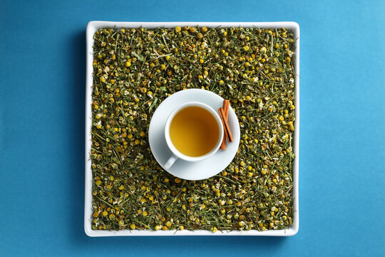 x&iacute;cara de ch&aacute; de camomila e canela sobre uma cama de flores secas arom&aacute;ticas