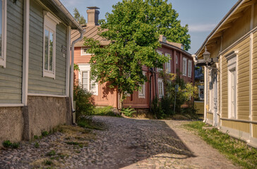 Fototapeta na wymiar Old street with pavement stones and wooden houses 