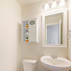 Square frame Interior of a white powder room with minimalist design