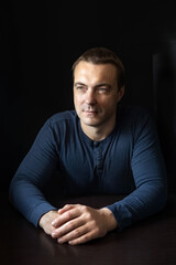 Portrait of a young man in a blue shirt in a dark key