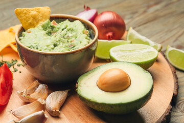 Bowl with tasty guacamole and nacho on table, closeup