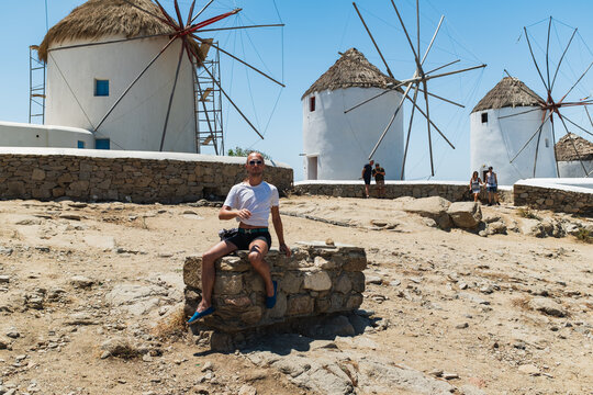 Young Gay Man Posing in Front of Iconic Windmills in Mykonos, Greece