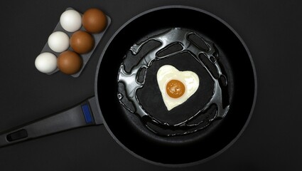 A frying pan with a fried egg in the shape of a heart and next to it half a dozen white and brown eggs, all on a black background, healthy cooking and cholesterol concept